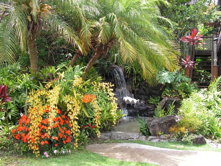 A beautiful waterfall inside the garden full of flowers