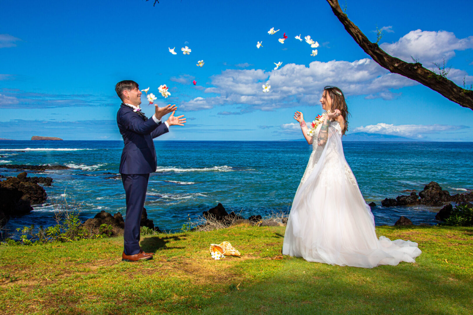 Wedding couple tosses flowers in the air to celebrate their wedding vows
