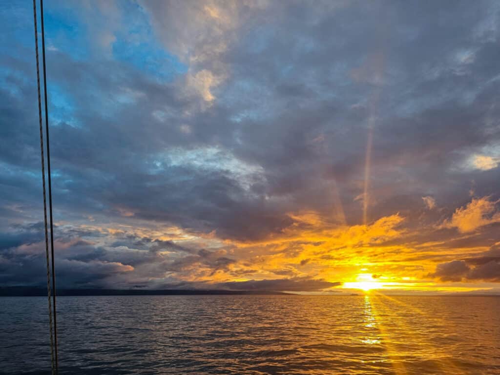 Sunset over a calm body of water with vibrant clouds.