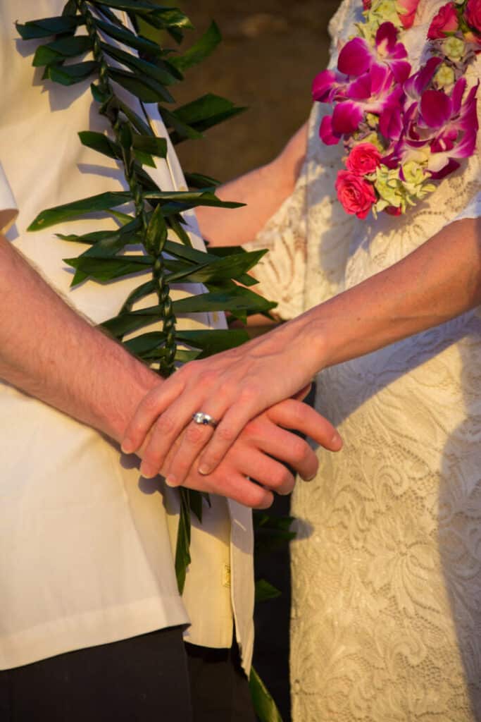 A couple holding a flower in hand