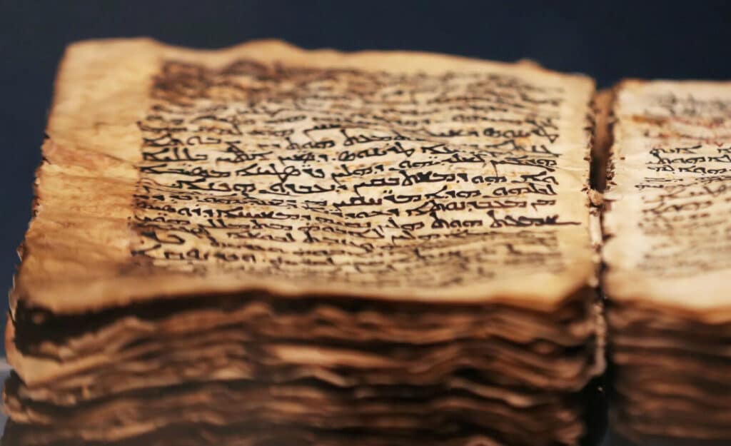 A close-up of an ancient manuscript with handwritten text on aged paper.
