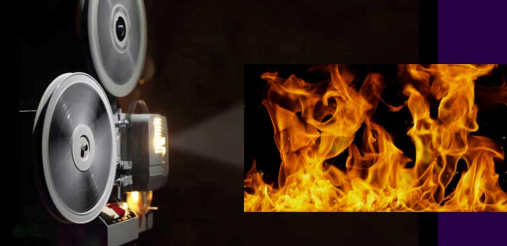 A close-up of a roaring orange fire inside a fireplace.