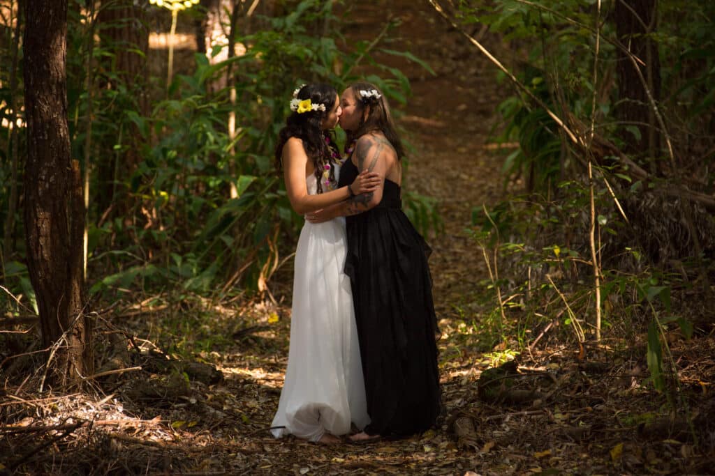 Two women embracing in a forest.