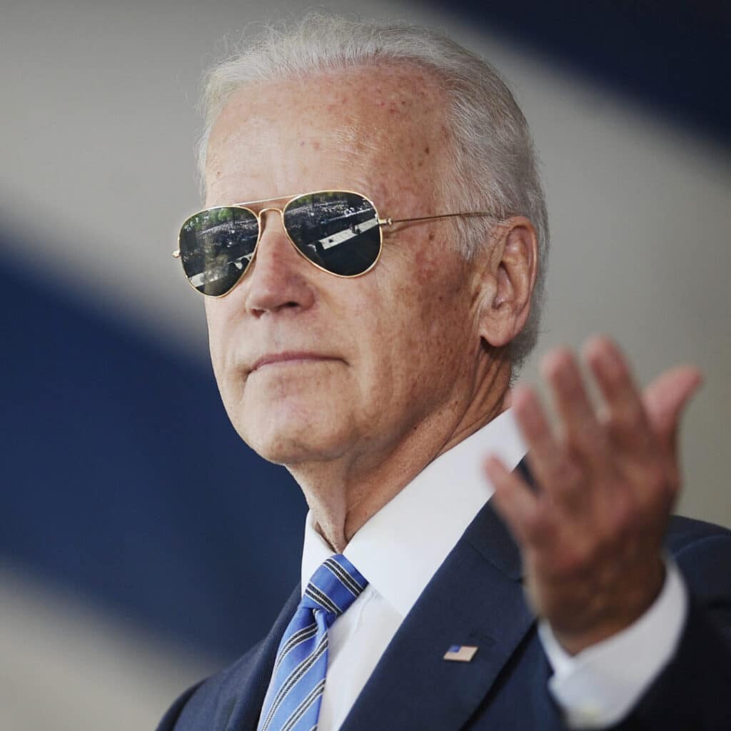 A man in sunglasses gestures while speaking.