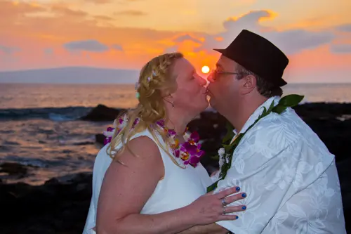 Husband and wife kissing for a sunset photo after their wedding in Maui