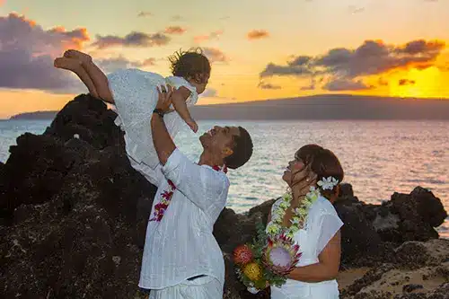 Family portait with a sunset in the background after a wedding ceremony.