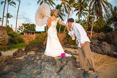 Husband and wife posing for a photo on a beach in Maui