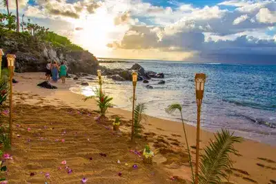 Beautiful wedding ceremony with tiki torches on a beach in Maui